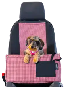 A small dog sits comfortably and safely in a dog car seat on the passenger seat of a car. The car seat is made with a soft yet durable material, providing a comfortable way for your dog to travel with you.