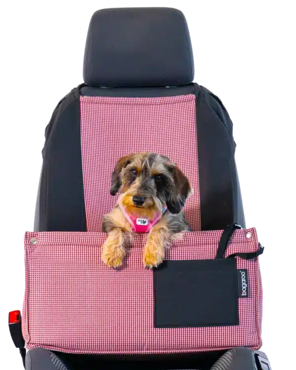 Un perro pequeño se sienta cómodamente y con seguridad en un asiento para perros en el asiento del copiloto de un coche. La silla de coche está fabricada con un material suave pero duradero y proporciona una forma cómoda de que su perro viaje con usted.